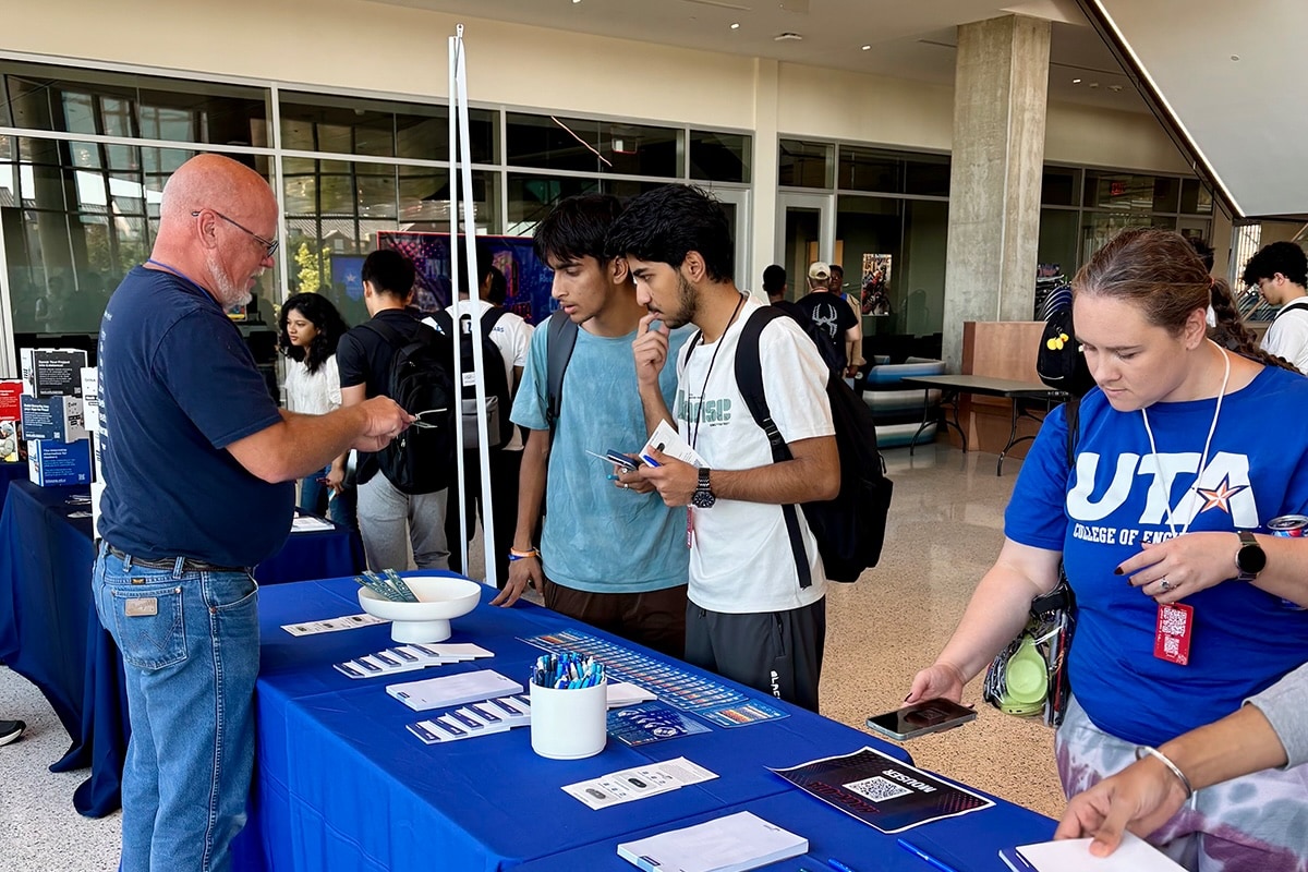 UTA students interacting with a tradeshow-style Mouser Electronics booth - opens in a new tab