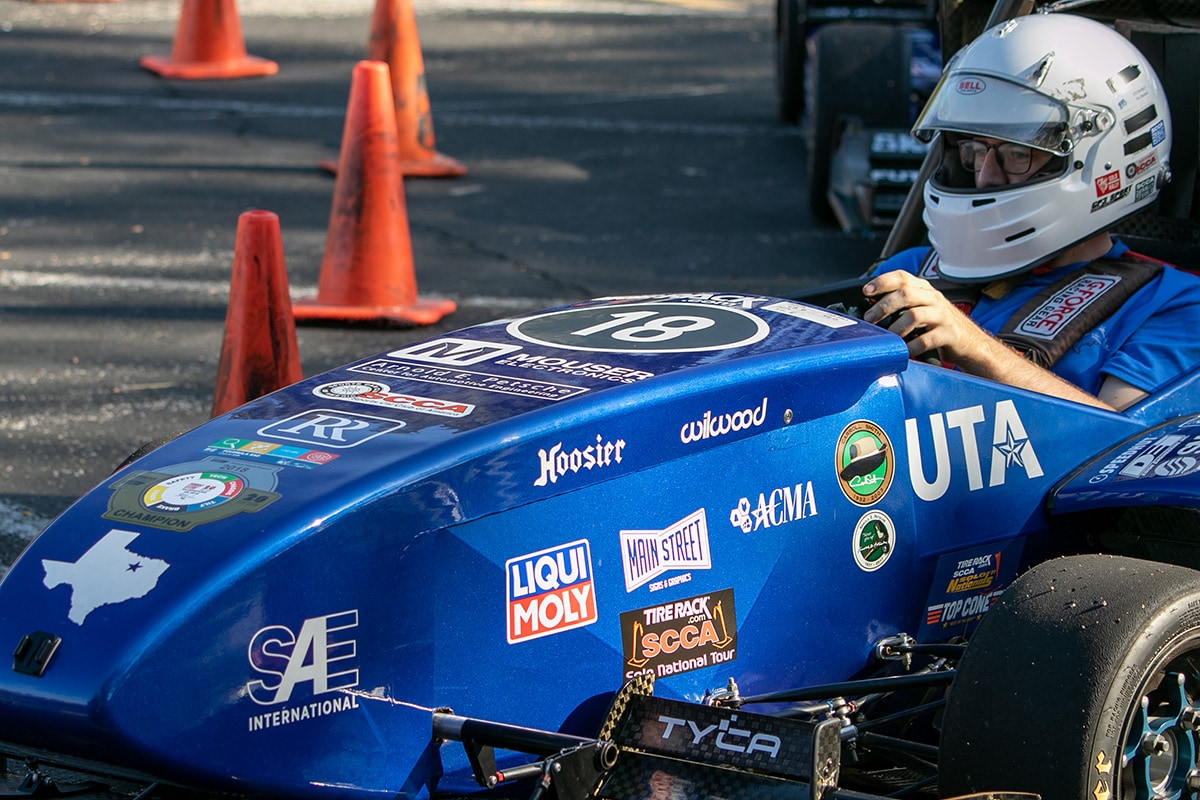 Man sitting in a UTA racecar - opens in a new tab
